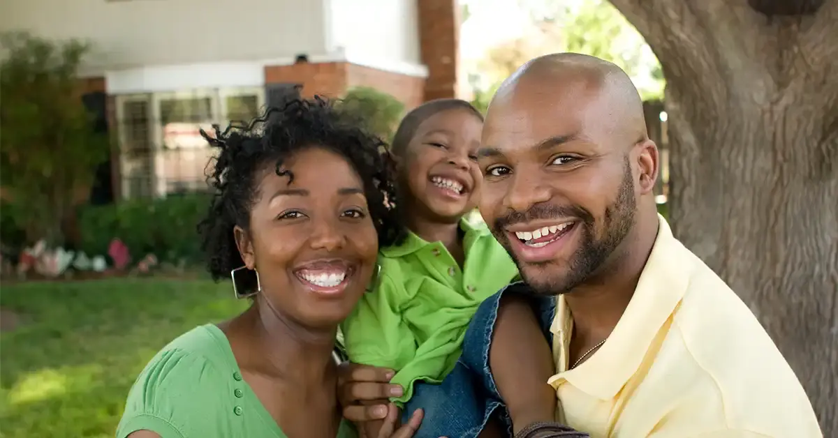 happy african american family outside their home smiling